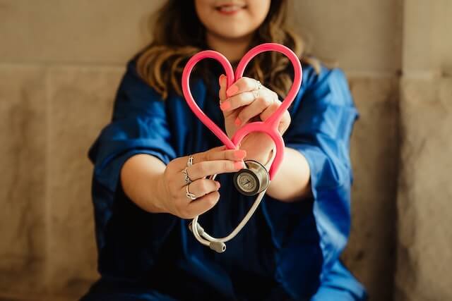 Young doctor holding a Stethoscope and showing a heart symbol from the tubing